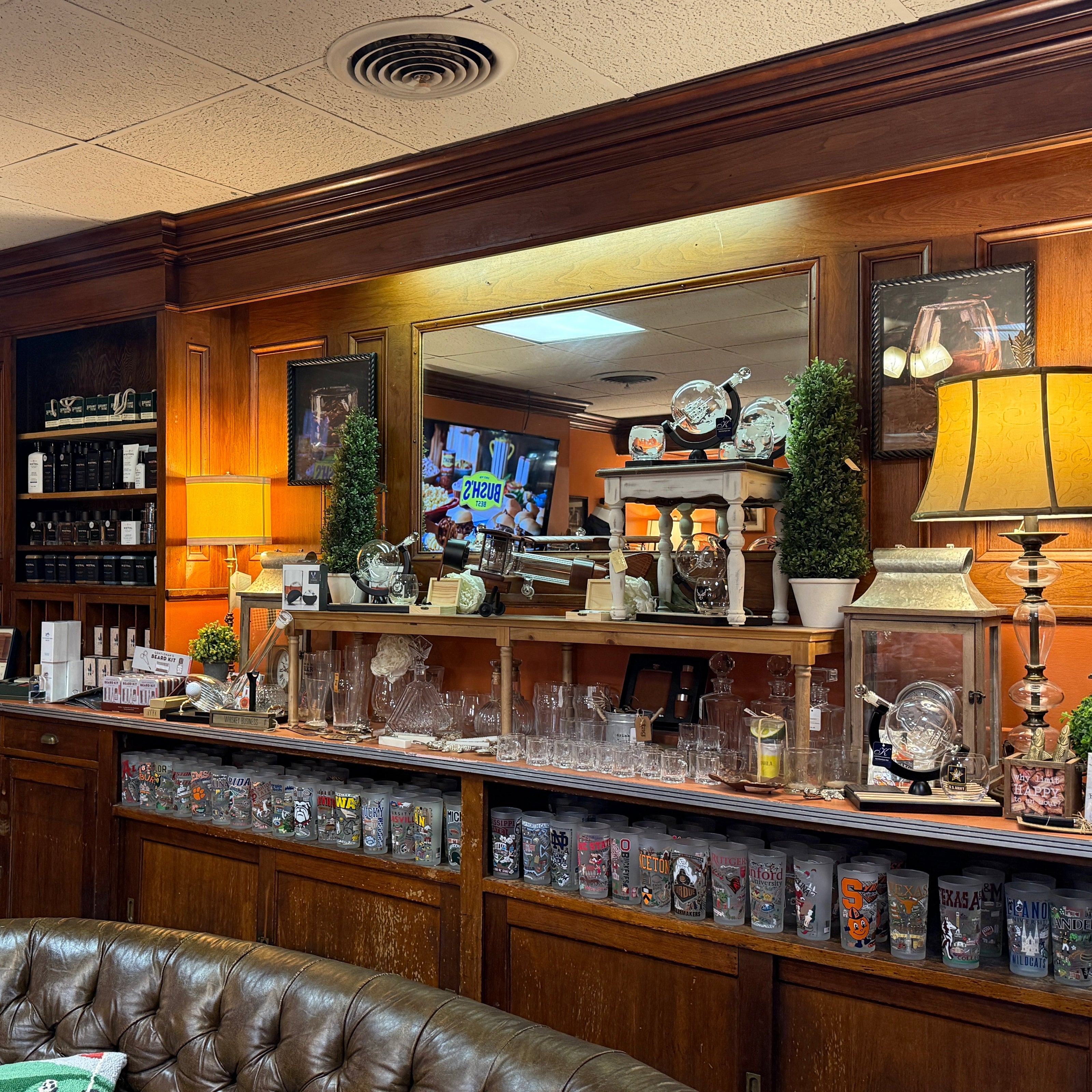 Bar area with wooden decor, shelves, and a leather couch.